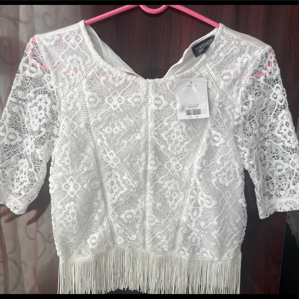 White lace crochet top with fringe on the bottom